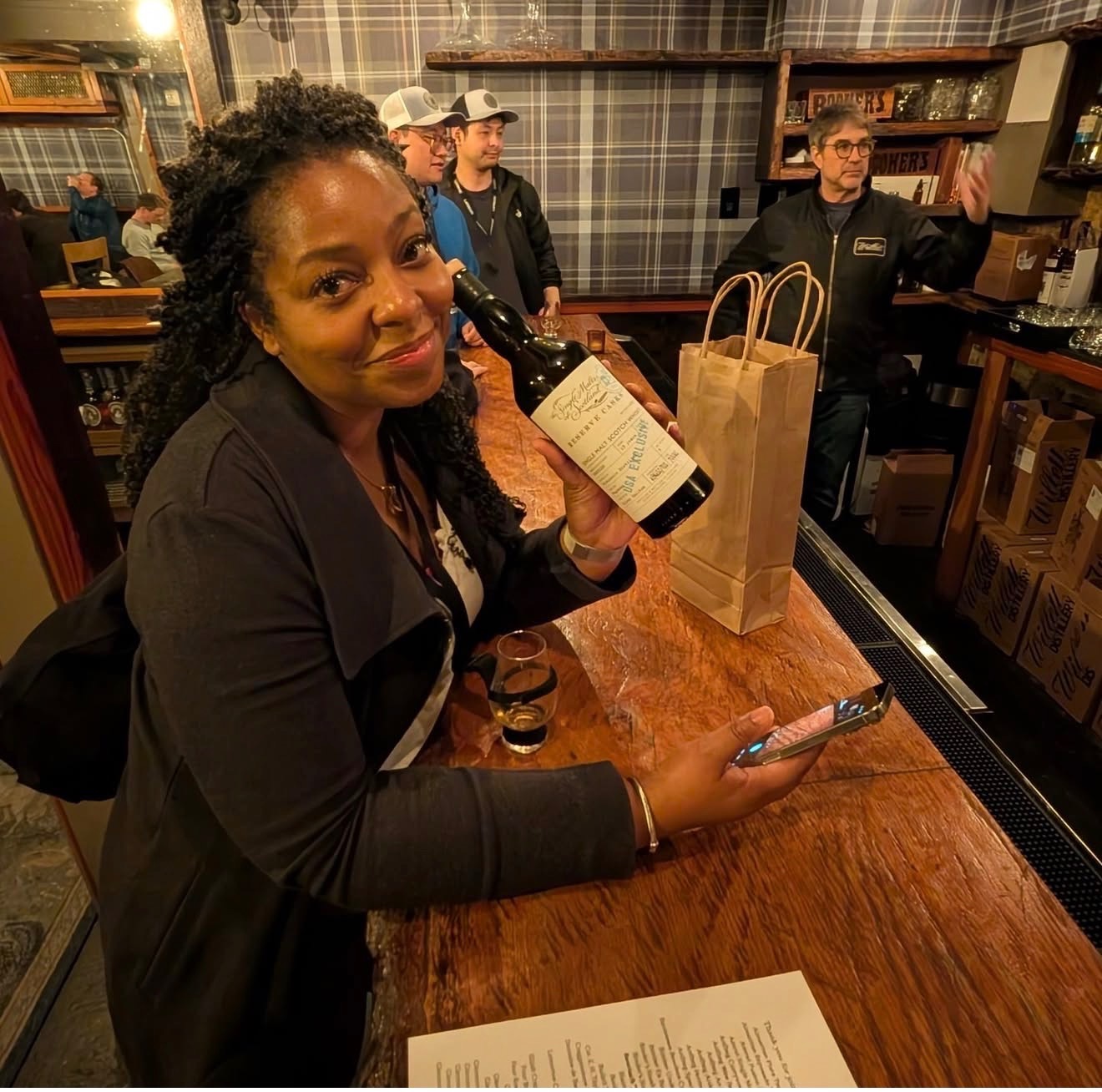 Kim holding a bottle at a spirits tasting